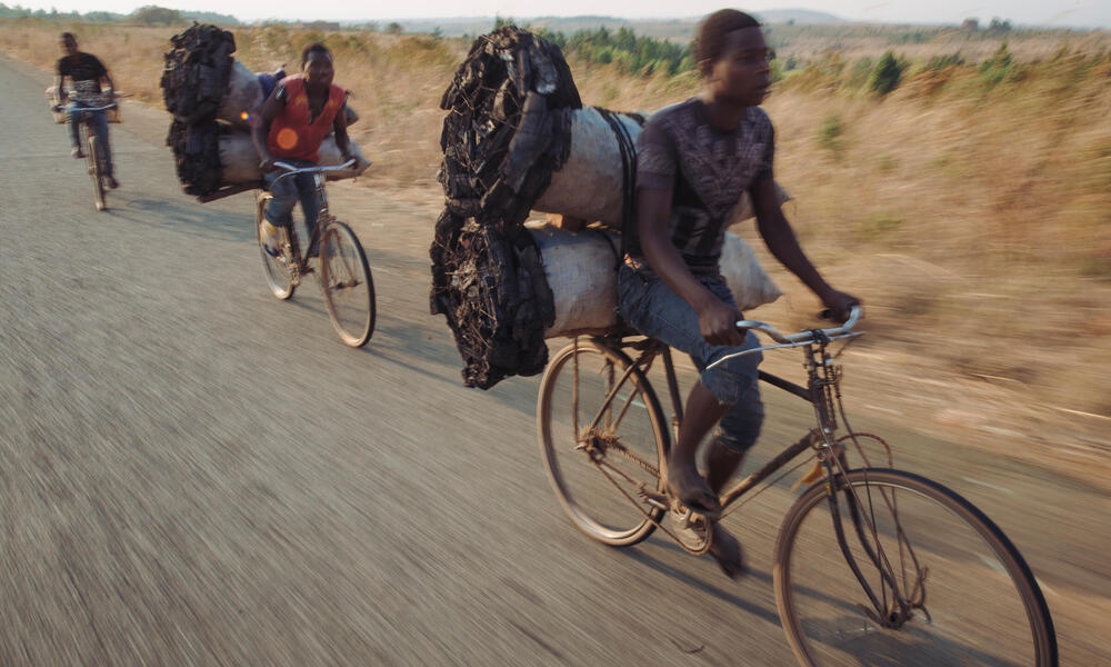 men transport charcoal by bicycle