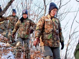 An all-female team of rangers treks through a snowy forest in China looking for clues of big cat whereabouts