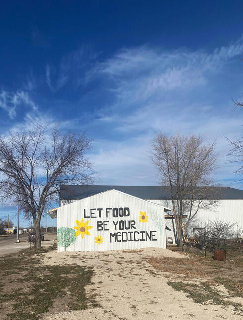 White building with Let Food Be Your Medicine painted on wall