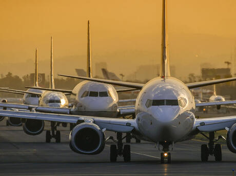 Airplanes in line to take off at sunset