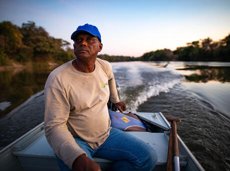 man traveling by boat down a river in Brazil