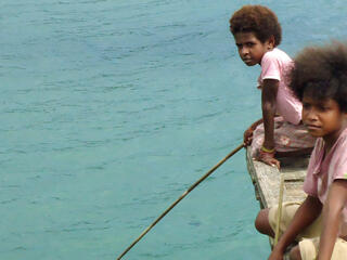 Boys on a dock in Bird's Head Seascape, West Papua, Indonesia