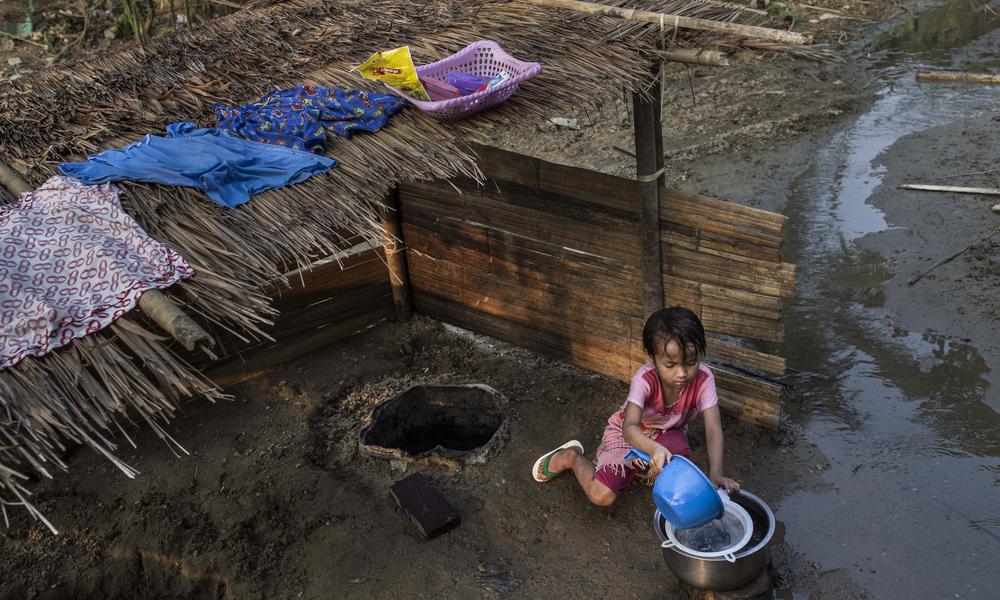 Little girl getting water from a well