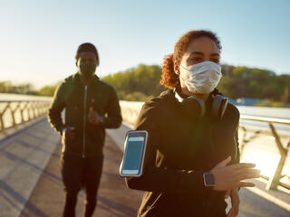 Two people running outside with face masks